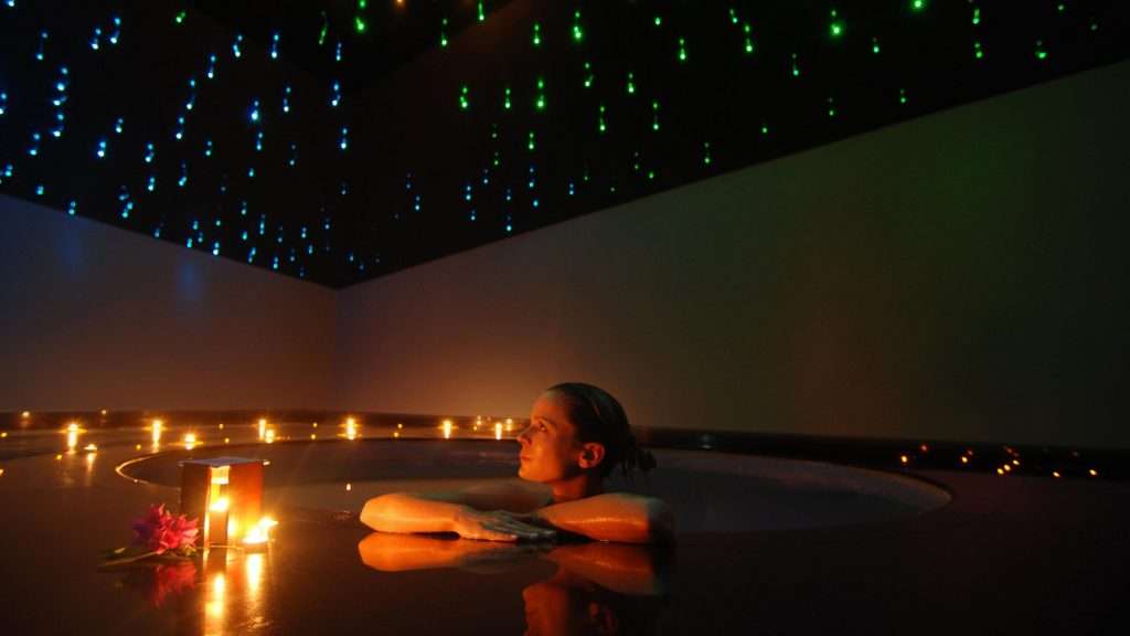 a woman is sitting in a hot tub.