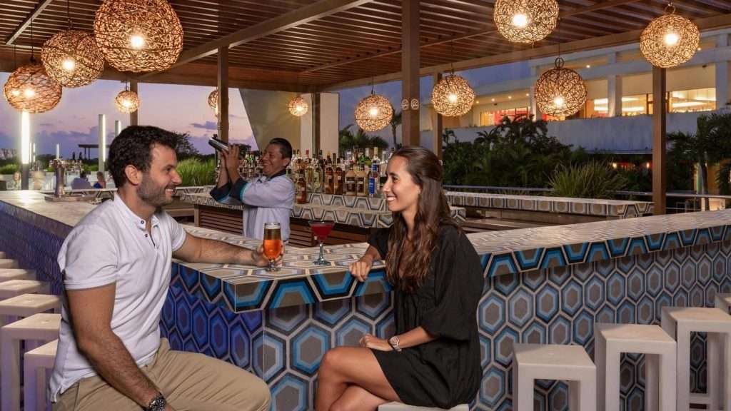 two people sitting at a bar at night.